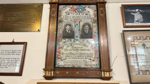John Devine/BBC Some old framed papers and documents from 1944 on the wall of a museum.