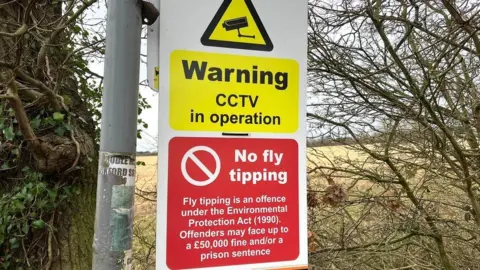Andrew Sinclair/BBC A sign warning against fly-tipping