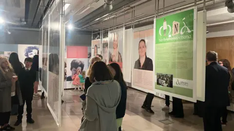 People standing around reading posters in an exhibition hall