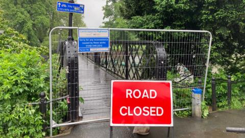 Road closed sign in front of a footbridge 