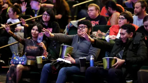 Netflix Fans in Los Angeles attending a Stranger Things screening, sitting in the audience with their arms outstretched