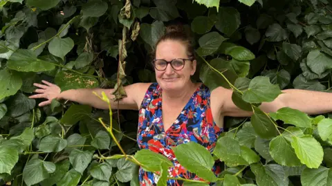 Woman in front of leaves
