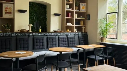 Peterborough Cathedral New cafe layout with clean seating and tables - and ornaments in wall nooks