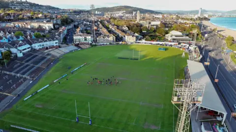 Getty Images Aerial view of Swansea's St Helen's ground. On the left of the stadium is a residential area. On the right is the main road which goes in and out of Swansea.