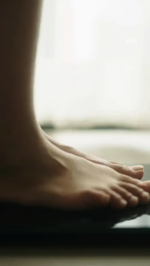 Someone standing on a set of scales 