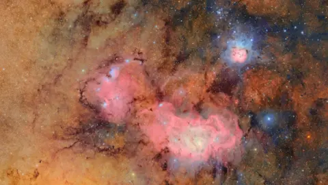 The pink, blue and orange clouds of gas and dust that comprise the Trifid nebula and the Lagoon nebula.