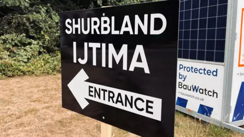 Shaun Whitmore/BBC A black and white sign that reads Shrubland Ijtima Entrance. 