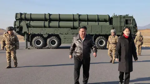 KCNA VIA KNS via AFP This picture taken on January 27, 2026 and released by North Korea's official Korean Central News Agency (KCNA) on January 28, 2026 shows North Korean leader Kim Jong Un (C) and his daughter Kim Ju Ae (2nd L) inspecting a test firing of the renewed large-caliber rocket launcher system, at an undisclosed location in North Korea.