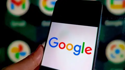 Getty Images A phone with the Google logo on it, with other Google products in the background