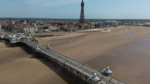 An aerial photograph taken with a drone shows people on the North Pier in Blackpool.