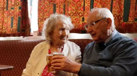 Connie and Dennis Cutts celebrating 70 years of marriage at the Dorman's Club with half a pint of lager each