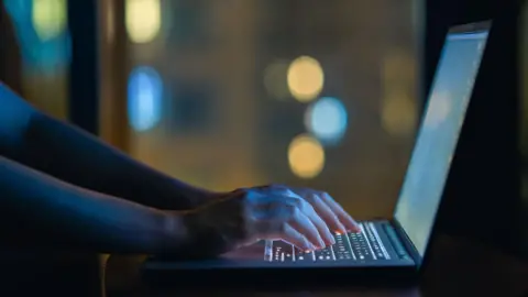 Getty Images woman typing on laptop 