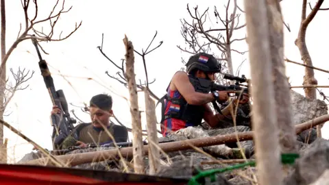 Nam Ree aims a sniper rifle towards the enemy position