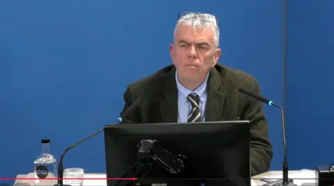 Undercover Policing Inquiry Man in dark jacket and tie gives evidence