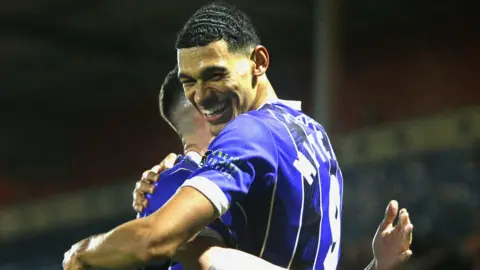 Kairo Mitchell celebrates scoring a goal for Rochdale in their 3-0 home win over Altrincham in November 2023