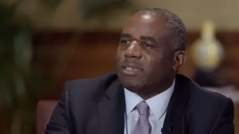 David Lammy wearing a suit with a purple tie