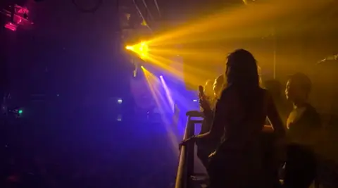 A girl dances on the top floor of Heaven to Abba