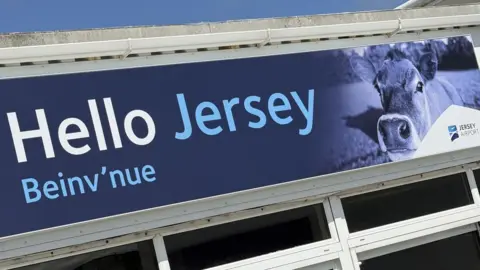 A banner reads Hello Jersey Beinv'nue in pale blue writing against a dark blue background with a picture of an inquisitive Jersey cow