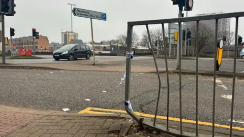 Horse Market at its junction with Lady's Lane. A metal barrier with remnants of police tape is shown as having been bent after being struck by a vehicle.