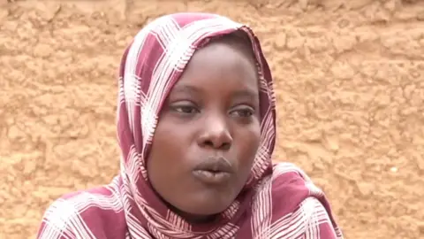 Alawia Babiker Ahmed, with a headscarf, is seen talking in Sudan's Tawila town