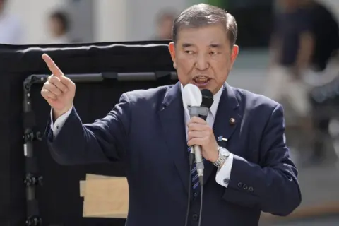 Getty Images Shigeru Ishiba holds a microphone to his mouth as he delivers a speech