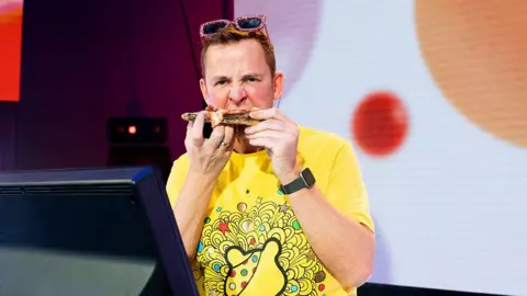 BBC Scott Mills eats a slice of pizza