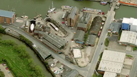 Getty Images An aerial image West Quay of Gloucester Docks in 2010, an industrial dockland with a canal at the top of the site and roads to the right and beneath it. A large ship basin can be seen, along with warehouses and boats.