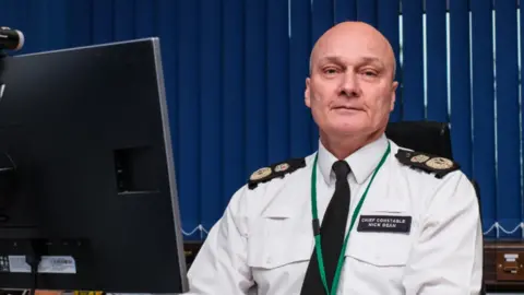 Cambridgeshire Constabulary Police chief in uniform at a desk