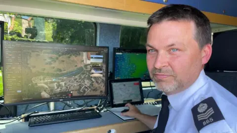 Andrew Turner/BBC Sergeant Danny Leach inside the control van