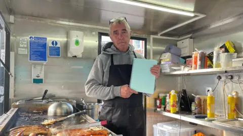 Charlie Pearson, AKA Sausage Man, standing in his stall