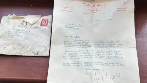 Adam Elshaw The letter is laid out on a table next to its envelope. It is on letterheaded paper from the hotel, Ashleigh Court, and typed with a signature at the bottom.