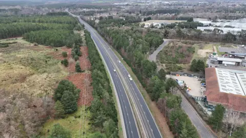 Shaun Whitmore/BBC An aerial drone shot showing the stretch of road where the shooting happened. Four vehicles are parked on the road.