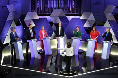 Mishal Husain is the moderator of the discussion with seven representatives of the main political parties in the July 4 General Election. L - R: Nigel Farage (Reform UK), Rhun Ap Iorwerth (Plaid Cymru), Daisy Cooper (Liberal Democrat), Stephen Flynn (Scottish National Party), Carla Denyer (Green Party), Angela Rayner (Labour Party), Penny Mordaunt (Conservative Party)