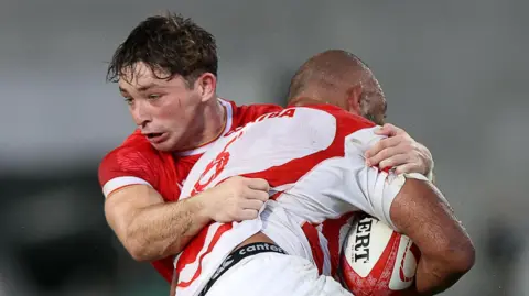 Dan Edwards tackles a Japan attacker