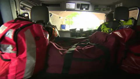 Inside a dark truck with red bags of equipment