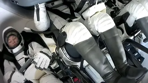 SpaceX The crew strapped into their seats as they descend from orbit.