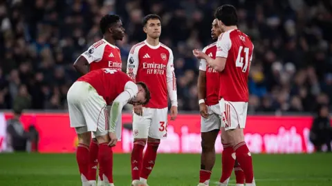 Arsenal players talking on the pitch