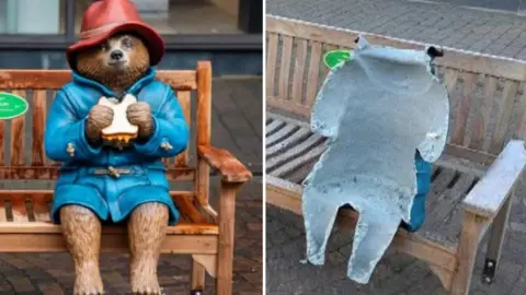 StudioCanal/Christopher Gibbins Two photos side-by-side. The photo on the left shows a statue of Paddington Bear, wearing a red hat and a blue coat, sitting on a bench and eating a marmalade sandwich. The photo on the right shows the damaged statue of Paddington on its bench. Only part of it is left, with the front completely torn off and the grey interior exposed