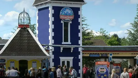 Alton Towers People queuing outside the Alton Towers entrance. It is a blue castle like building.