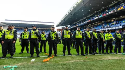 A line of police oficers on the pitch at Ibrox.