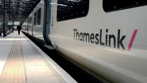 A white train with ThamesLink branding painted on the side.