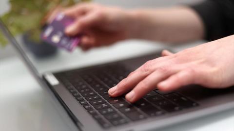 Person using laptop and credit card