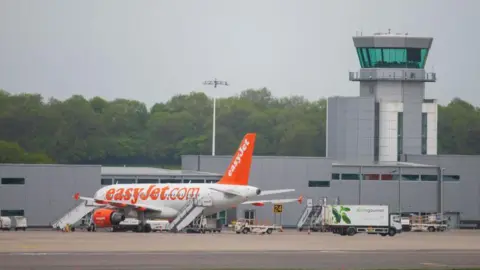 A white and orange easyJet plane parked outside Bristol Airport. 