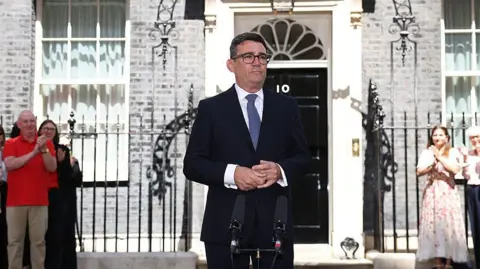 Getty Images Andy Burnham outside Number 10. He is wearing a dark suit and blue tie