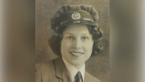 Supplied A black and white photo of Ethel Smith in military uniform. She has short, curly dark hair and is smiling at the camera.