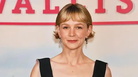 Carey Mulligan smiling at the camera as she attends the Gala Screening of "The Ballad Of Wallis Island" at The Ham Yard Hotel