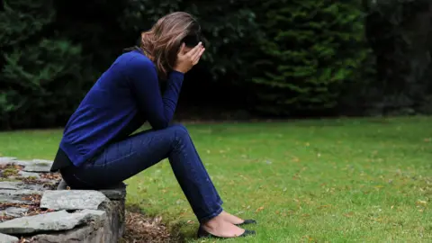  PA A woman with her head in her hands