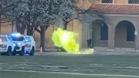 Green fire is coming out of a manhole at Texas Tech University.