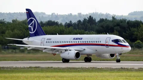 Reuters file image of Sukhoi superjet on a runway with trees in the background