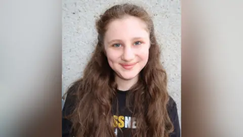 Brassneck Youth Theatre A head shot of Mary-Kate. She is smiling at the camera. She has long light brown hair.